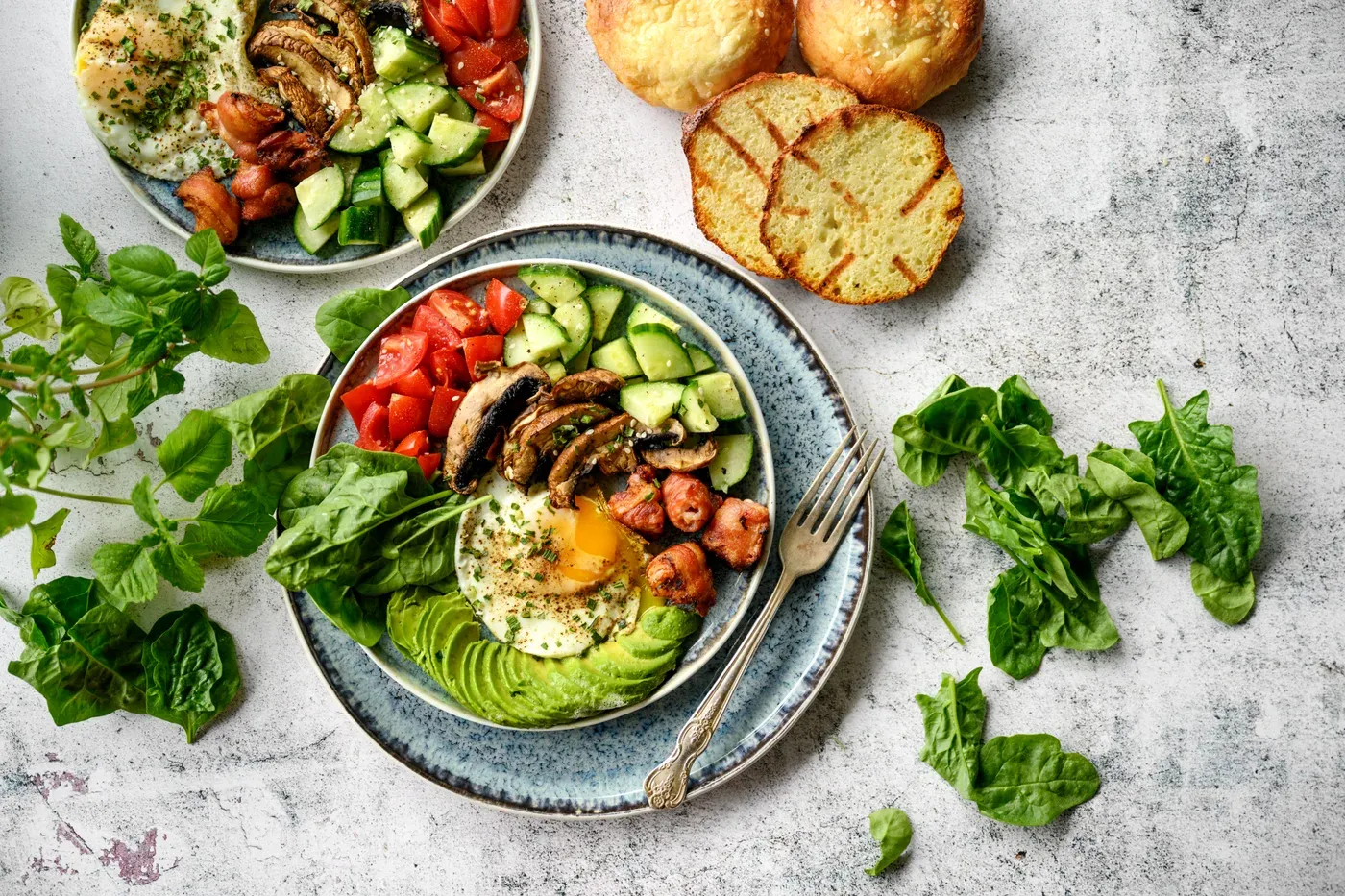Breakfast bowls with fried egg, avocado, mushrooms, tomatoes and spinach