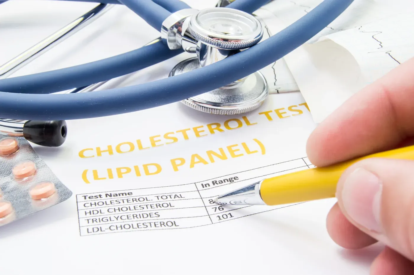 Cholesterol lipid panel test results with a stethoscope and pen