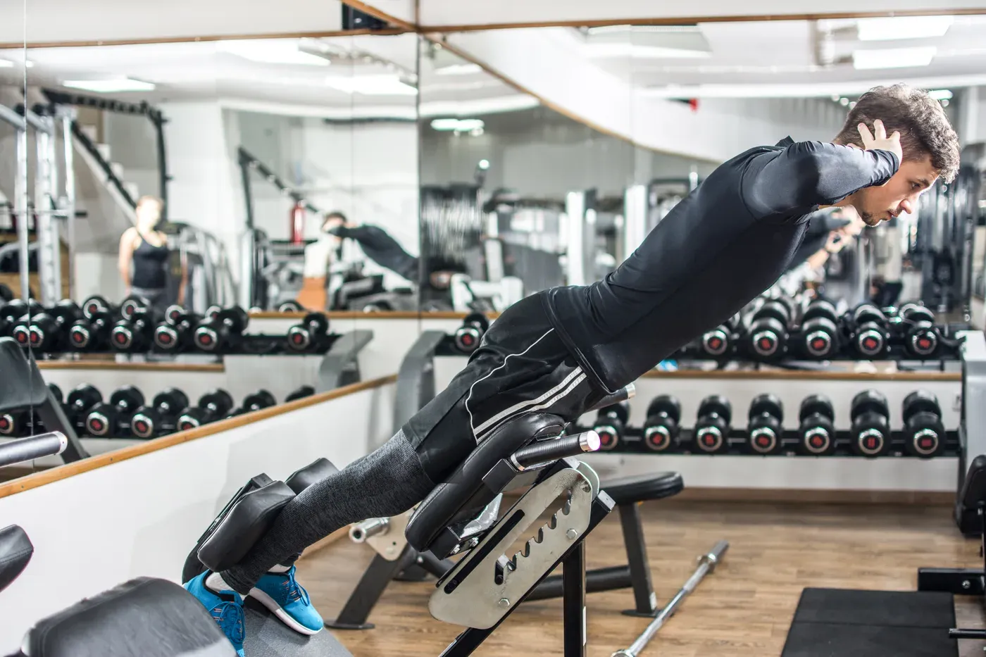 Man doing a back extension on a Roman chair in a gym