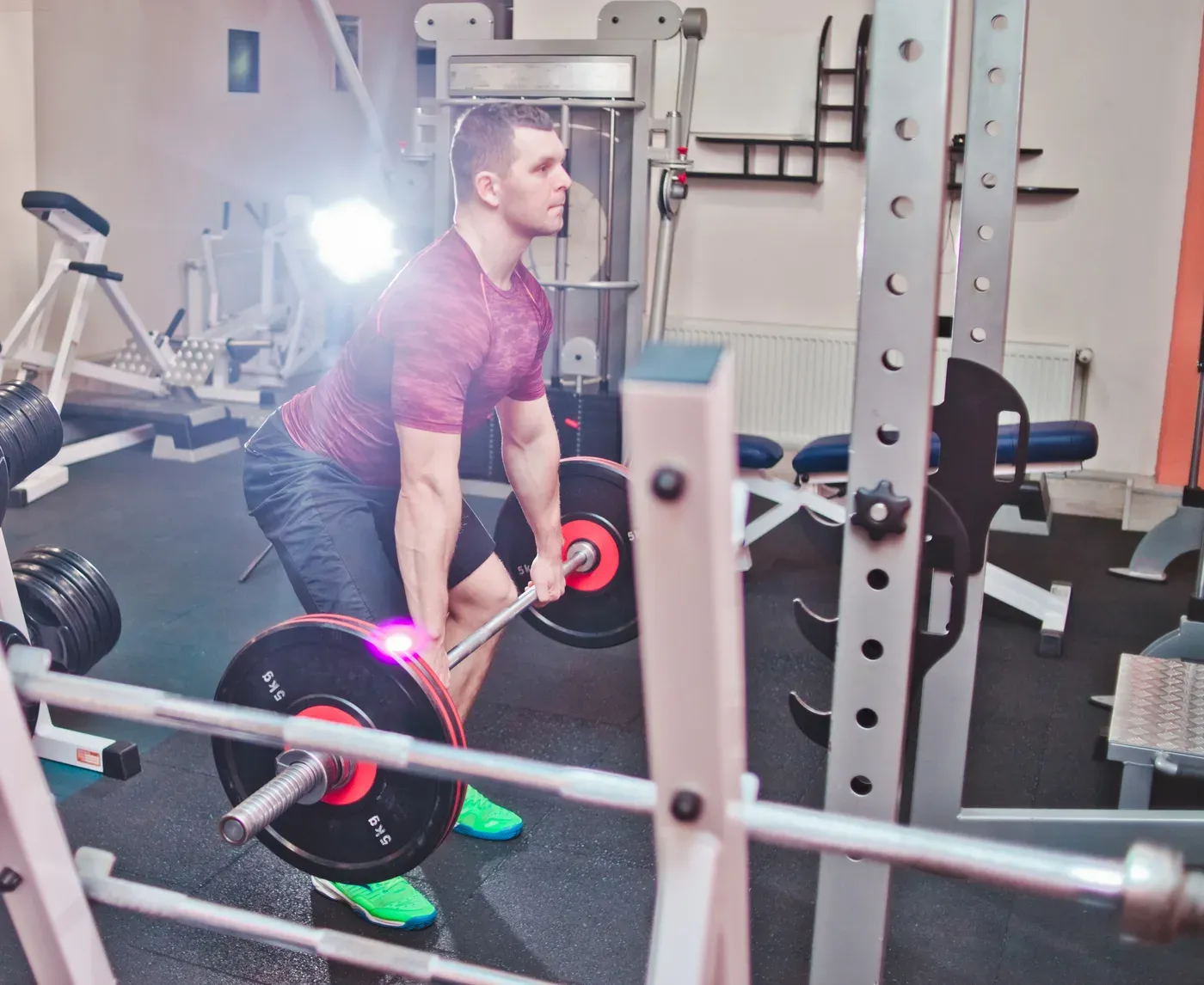 Man setting up a barbell deadlift in a gym