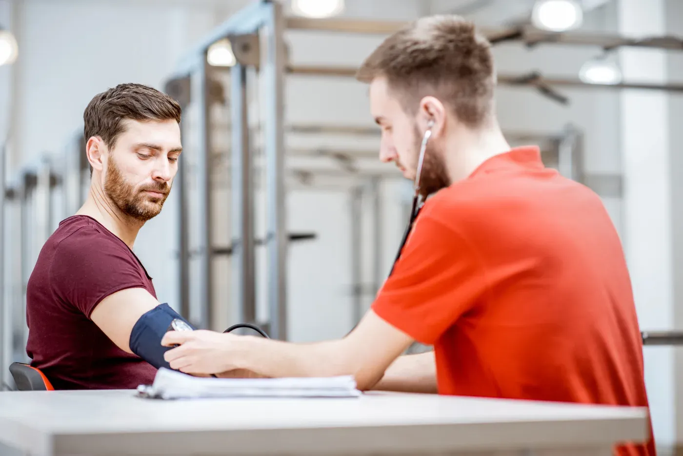Man having his blood pressure taken by a clinician at a table