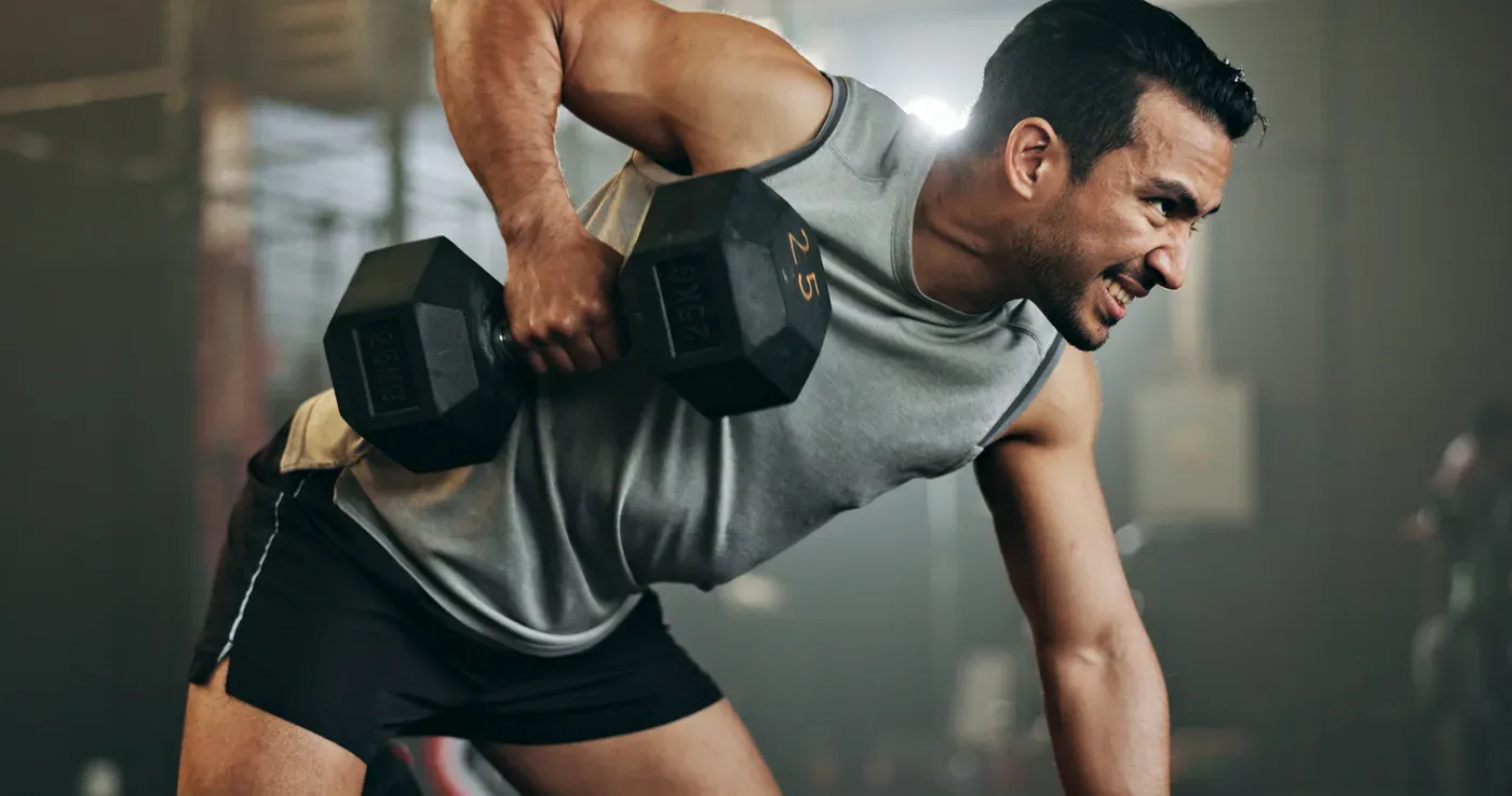 Man doing a one-arm dumbbell row braced on a bench