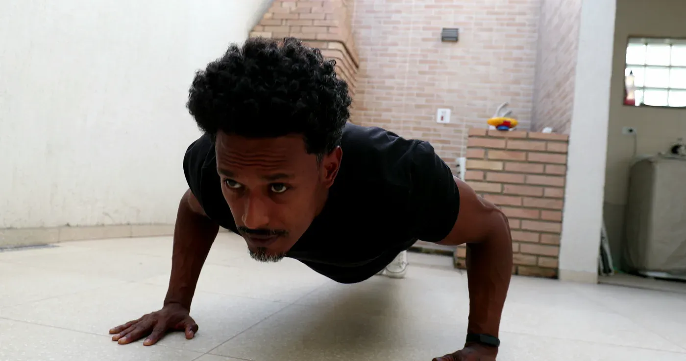 Man doing a push-up on a tiled floor at home