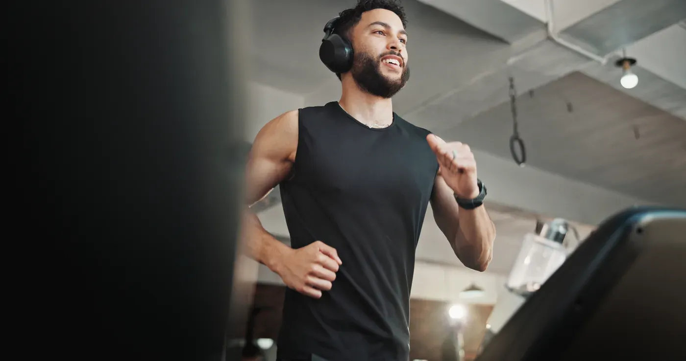 Bearded man in headphones running on a treadmill