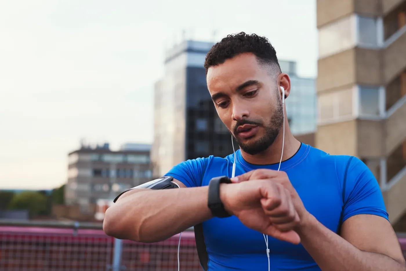 Runner checking his smartwatch on a city street