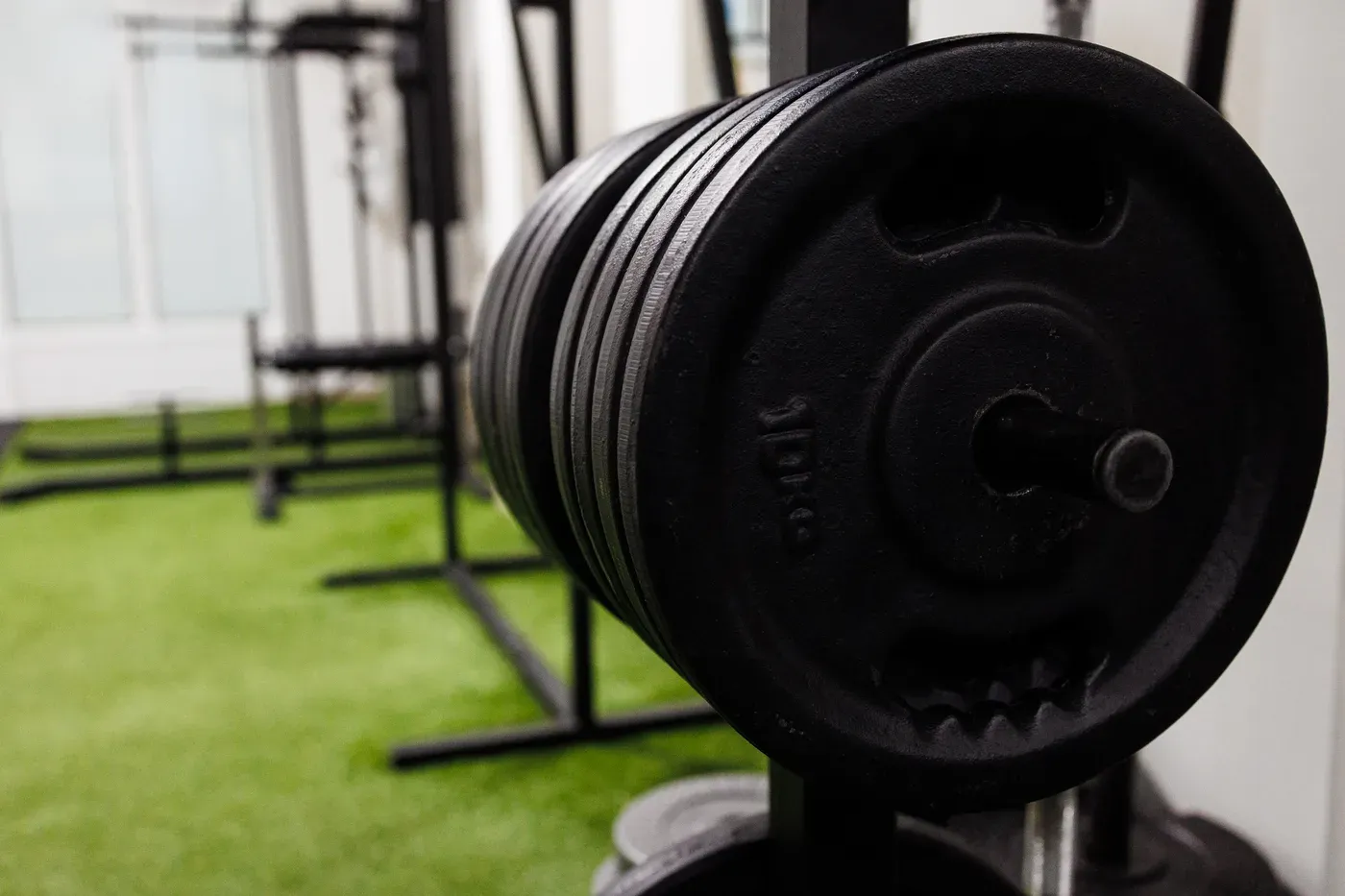 Stack of black iron weight plates on a rack in a gym